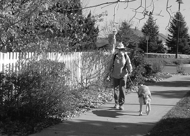 Volunteer walking a senior citizen's dog