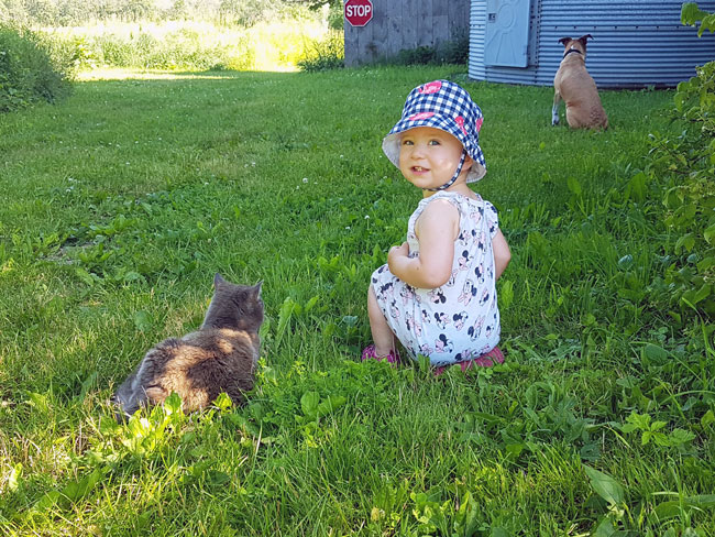 Ellie sitting in the grass with Ralph and Baxter
