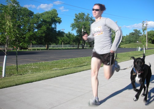 Woman and black lab mix running