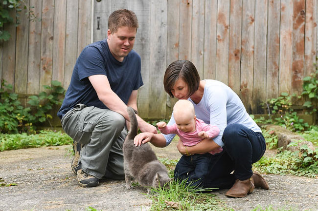 Baby petting the barn cat
